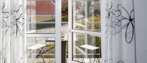 Une pièce dotée d’une porte-fenêtre coulissante donnant sur une terrasse extérieure.