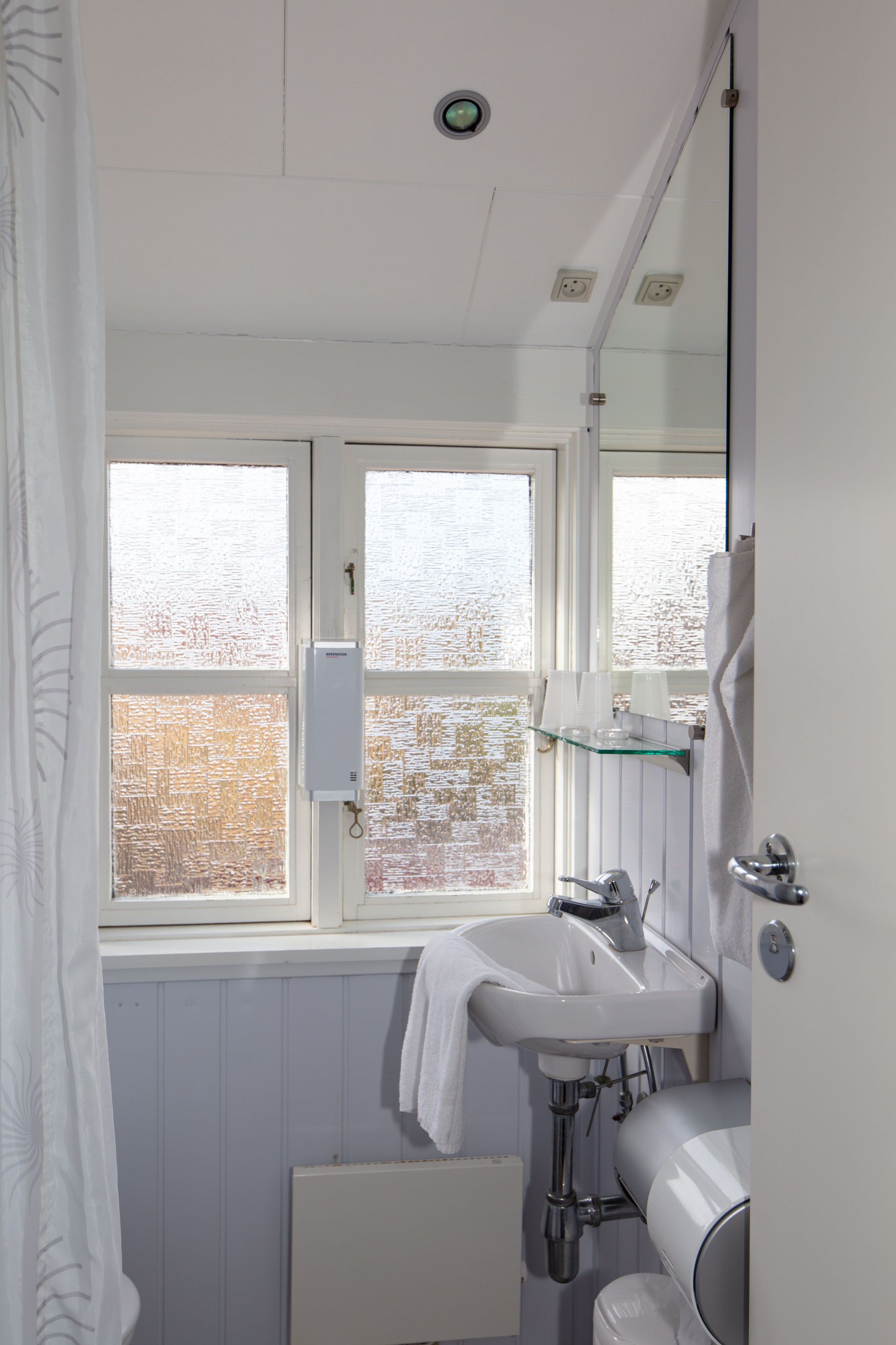 A bathroom with a window, a sink, and a toilet.