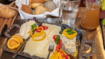 Un plat amb formatge, fruites i pa.