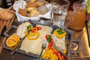 A meal with cheese, fruits, and bread on a tray.