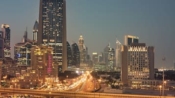 A cityscape with high-rise buildings, including a hotel with "ROYAL" illuminated on its facade.