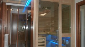 A modern interior with a glass partition, wooden paneling, and a ceiling light fixture. - IL POGGETTO DI MERLI SILVIA & C. SAS (Tavoleto)