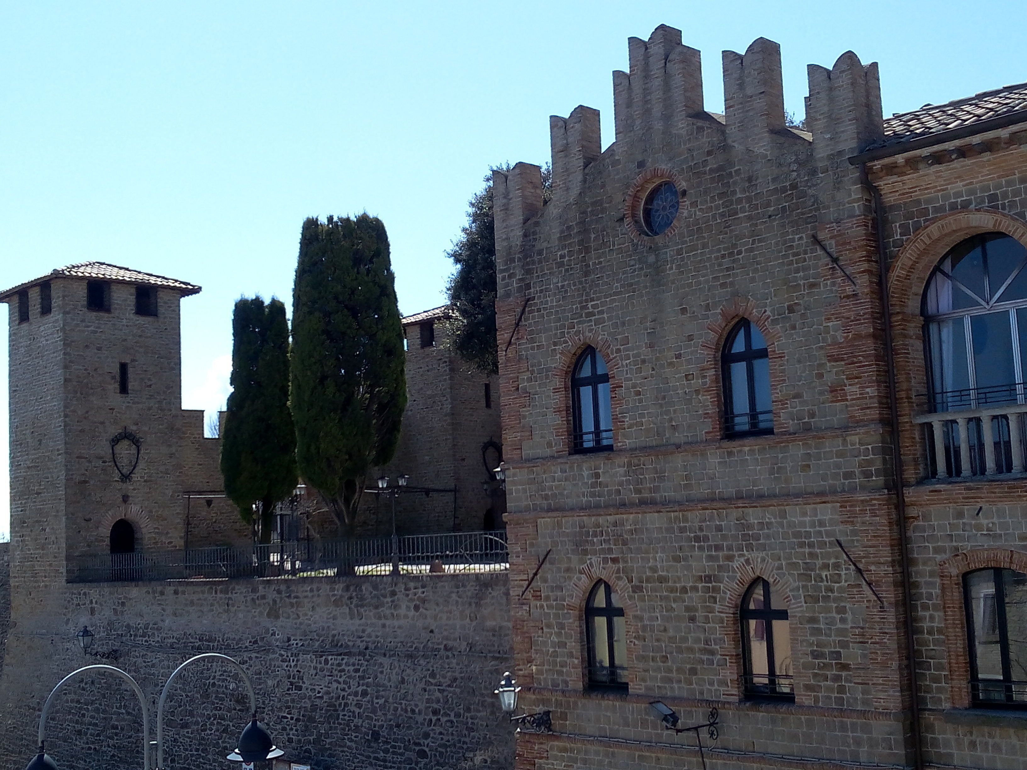 Un edificio histórico de piedra con ventanas de arco y una torre.