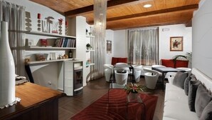 A modern living room with a fireplace, white furniture, and a wooden ceiling. - IL POGGETTO DI MERLI SILVIA & C. SAS (Tavoleto)