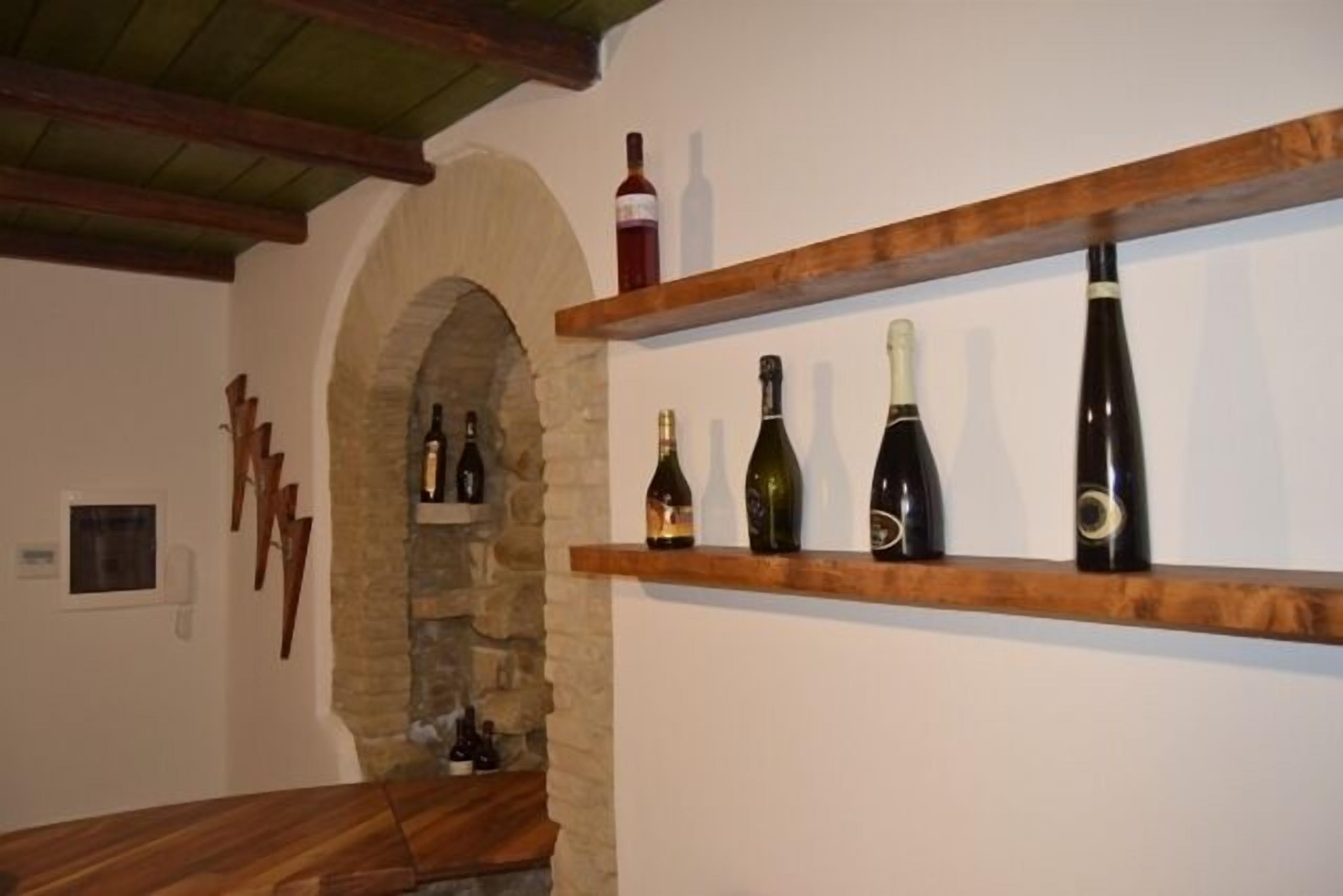 Uma adega com prateleiras de madeira repletas de garrafas de vinho.