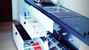 Una cucina con forno a incasso, lavello e piano di lavoro con diversi utensili da cucina.