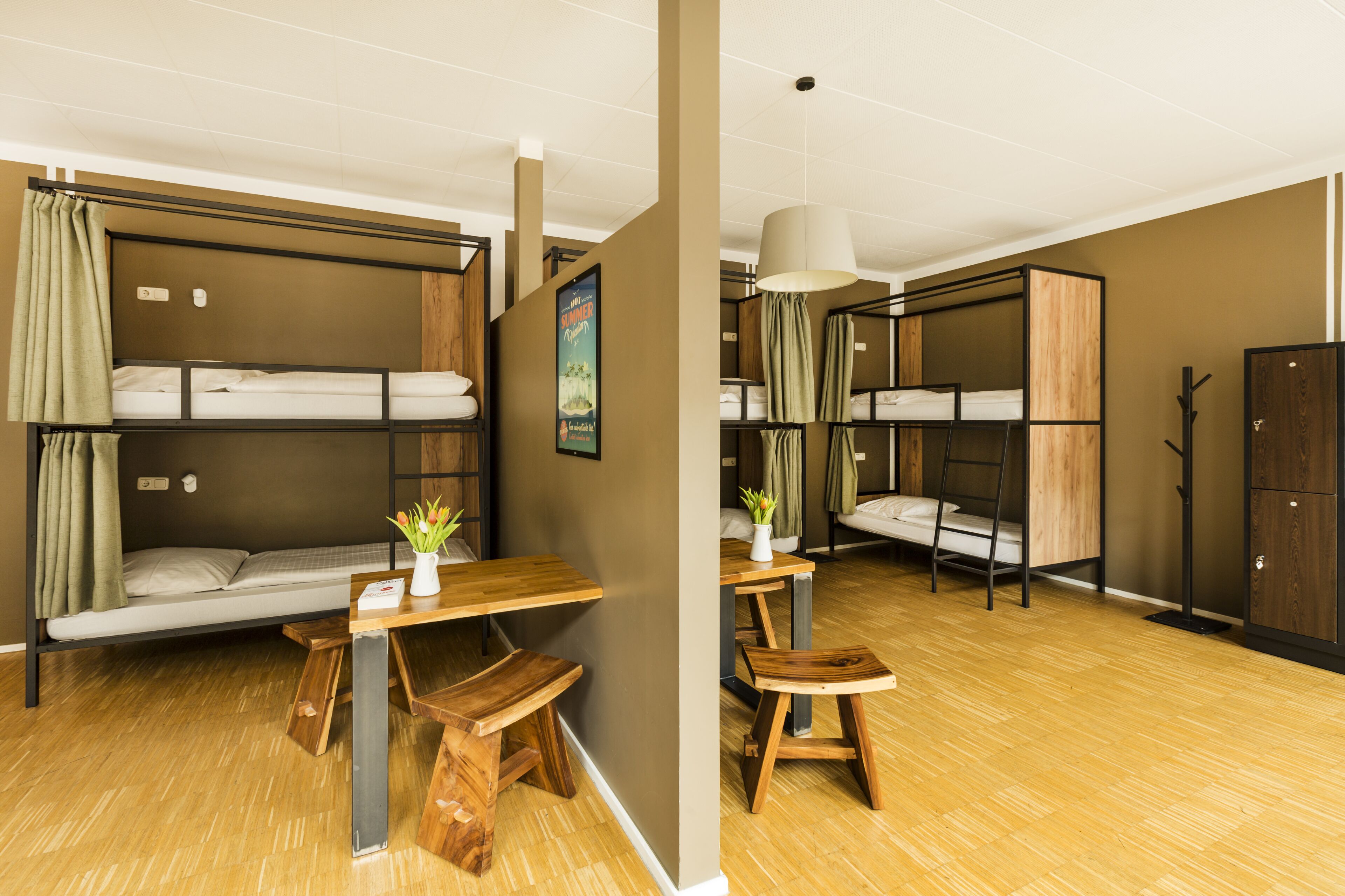 A room with bunk beds, a wooden table, and a bench.