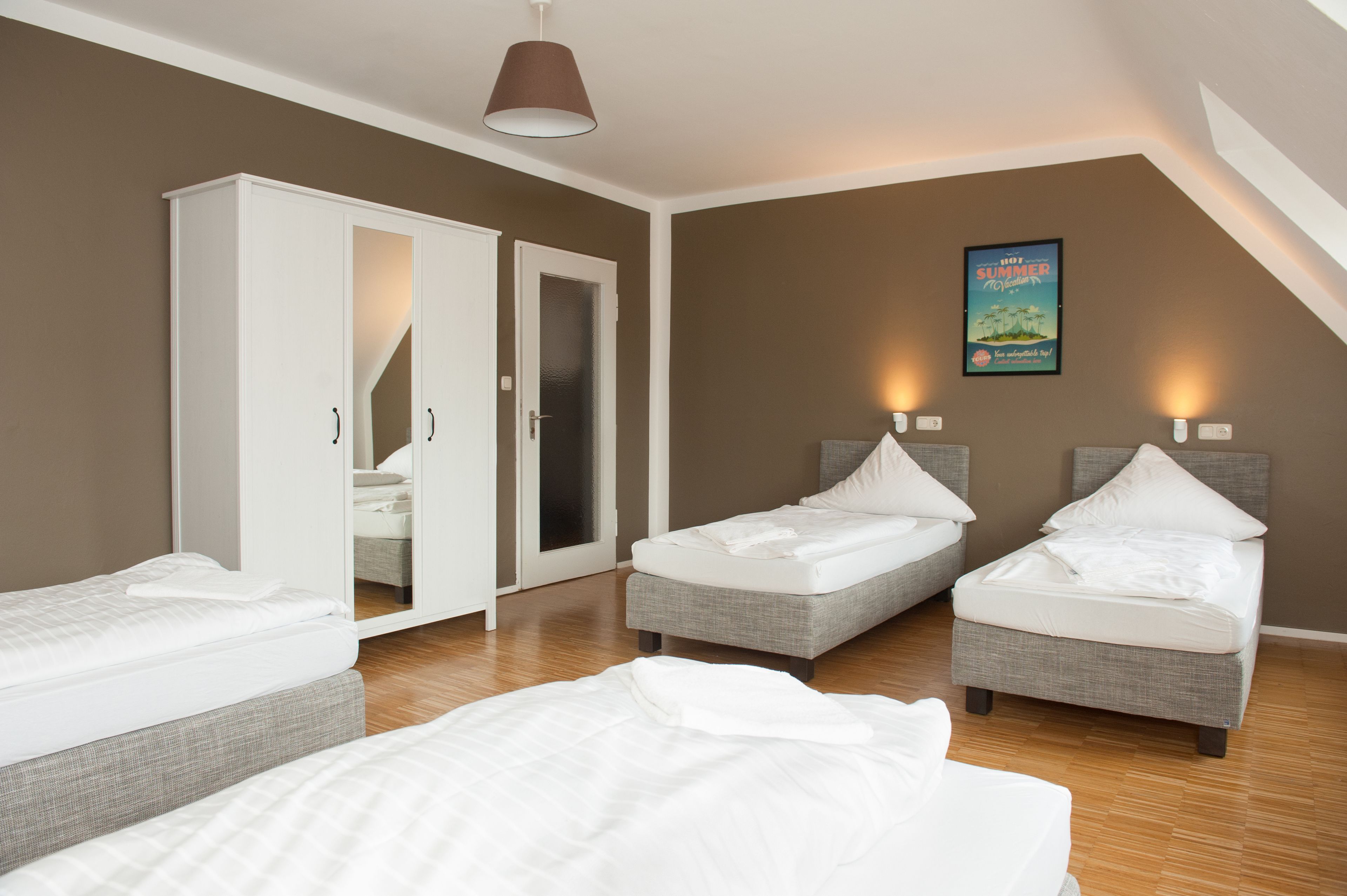 Un dormitorio con dos camas individuales, un armario y un cartel en la pared.