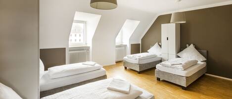 Een moderne hotelkamer met twee bedden, een groot raam en uitzicht op de stad.