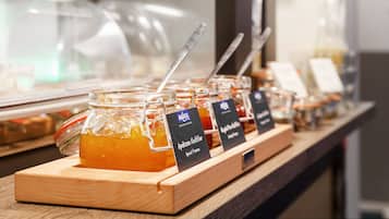 A display of honey jars with labels, a spoon, and a wooden board.