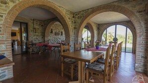 Un espace repas agrémenté d’une arche en briques, d’une table en bois et de chaises.