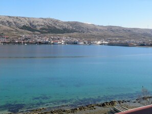 A coastal town with buildings along the shoreline and a clear view of the water. - Guest house Revelin (Pag)