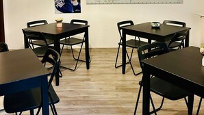 Ein Zimmer mit einer großen Weltkarte, einem Rennposter und einem Tisch mit Stühlen.