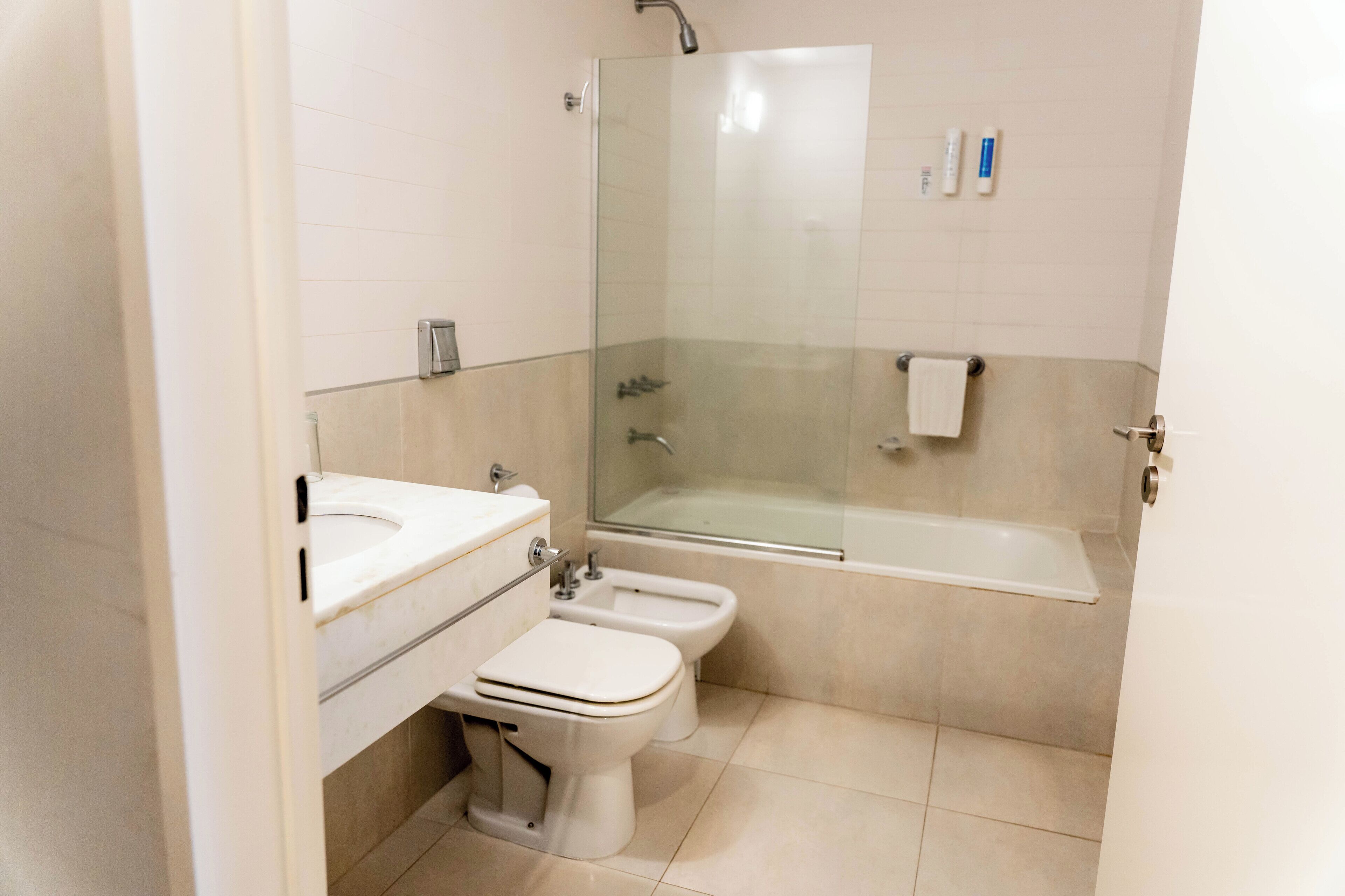 Un baño moderno con ducha de vidrio, bañera, inodoro y bidé.