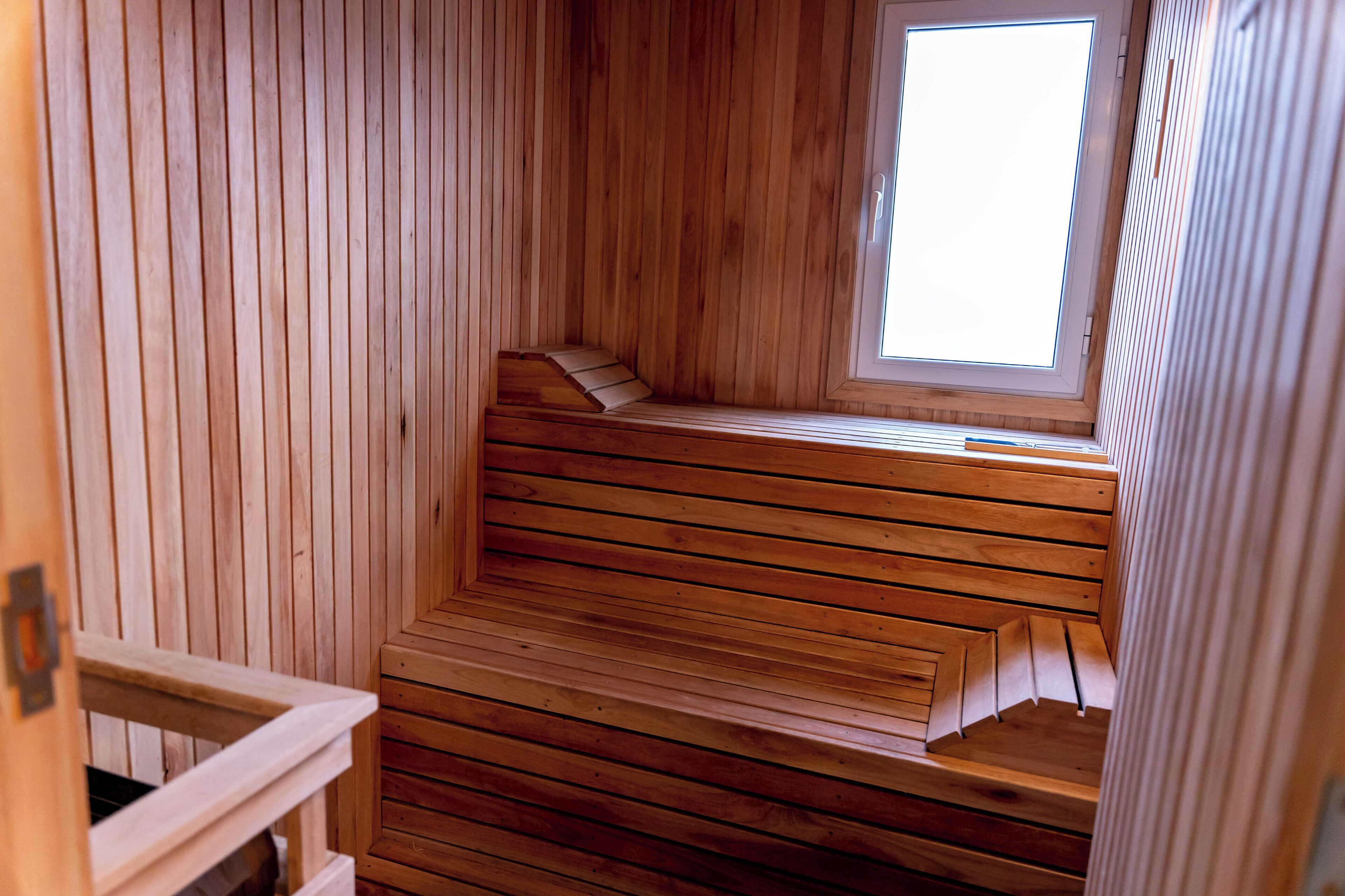 Una sauna con bancos de madera y tragaluces.