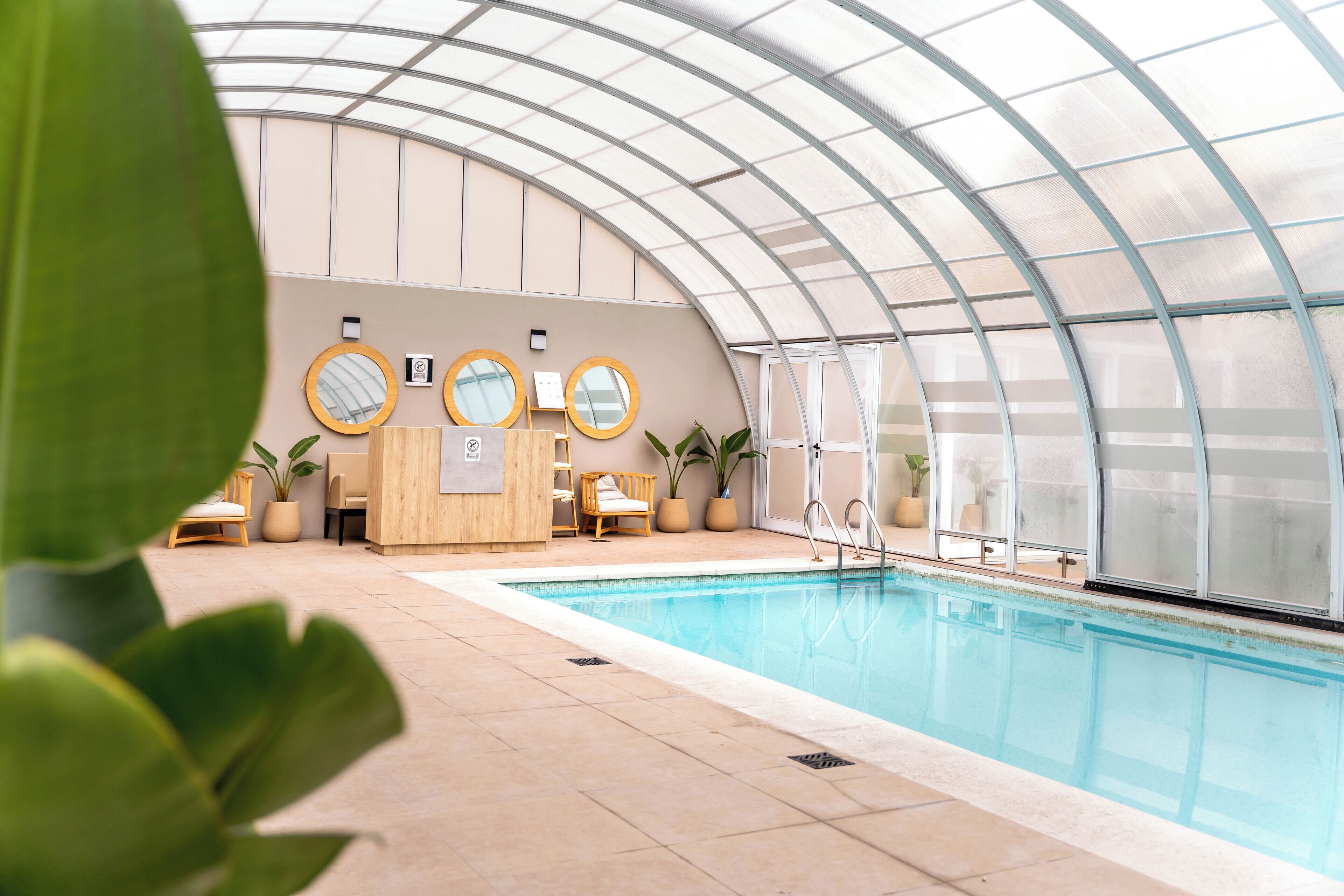 Una piscina techada, sillones reclinables de piscina