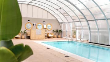 Una piscina techada, sillones reclinables de piscina