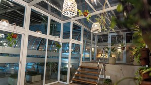A modern interior with glass walls, a staircase, and potted plants. - O2 Hoteles Mar del Plata (Mar del Plata)