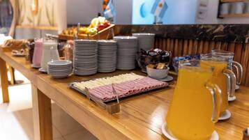 Una mesa de buffet con diversos alimentos y bebidas.