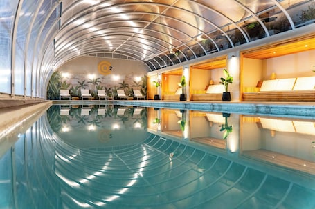 Una piscina techada, sillones reclinables de piscina