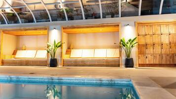 Un área de piscina interior moderna con asientos y taquillas.