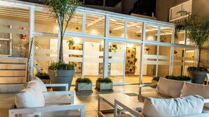 An outdoor seating area with white furniture and potted plants. - O2 Hoteles Mar del Plata (Mar del Plata)