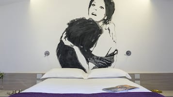 Ein Schlafzimmer mit einem großen Bett, einer violetten Tagesdecke und einem Buch auf dem Bett.