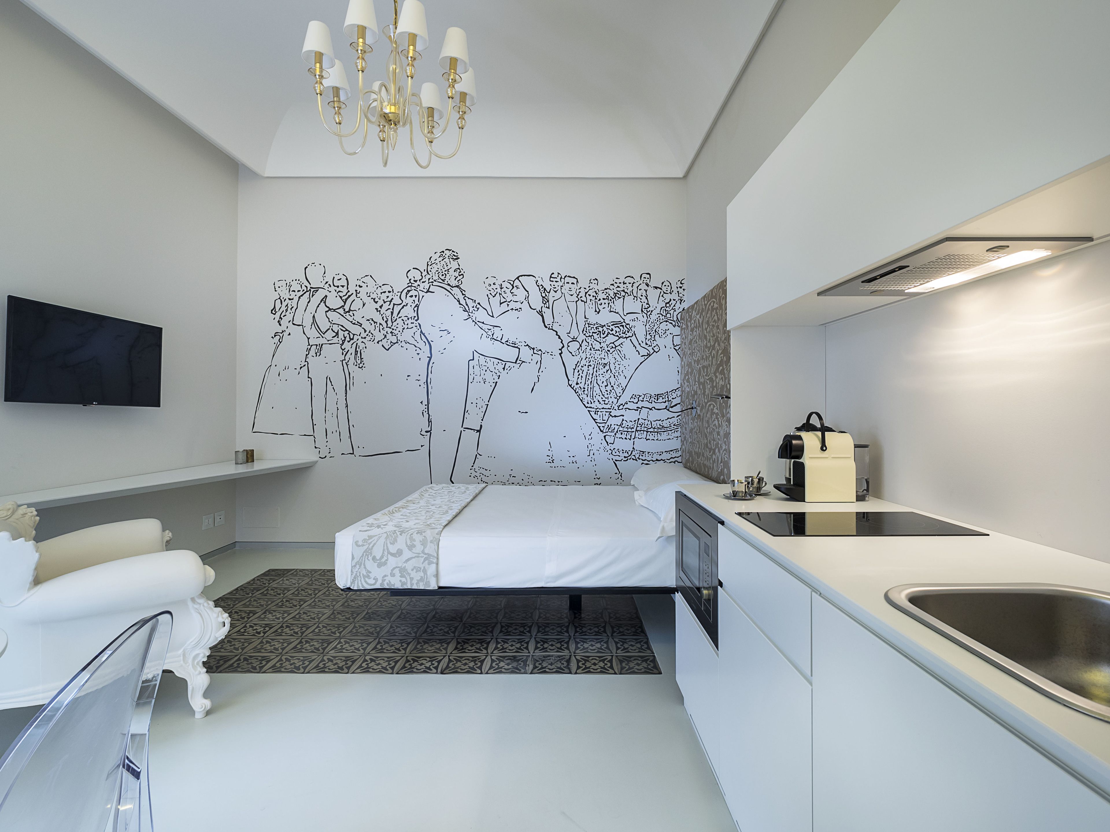 Un dormitorio moderno con cama, televisor, candelabro y un mural en la pared.