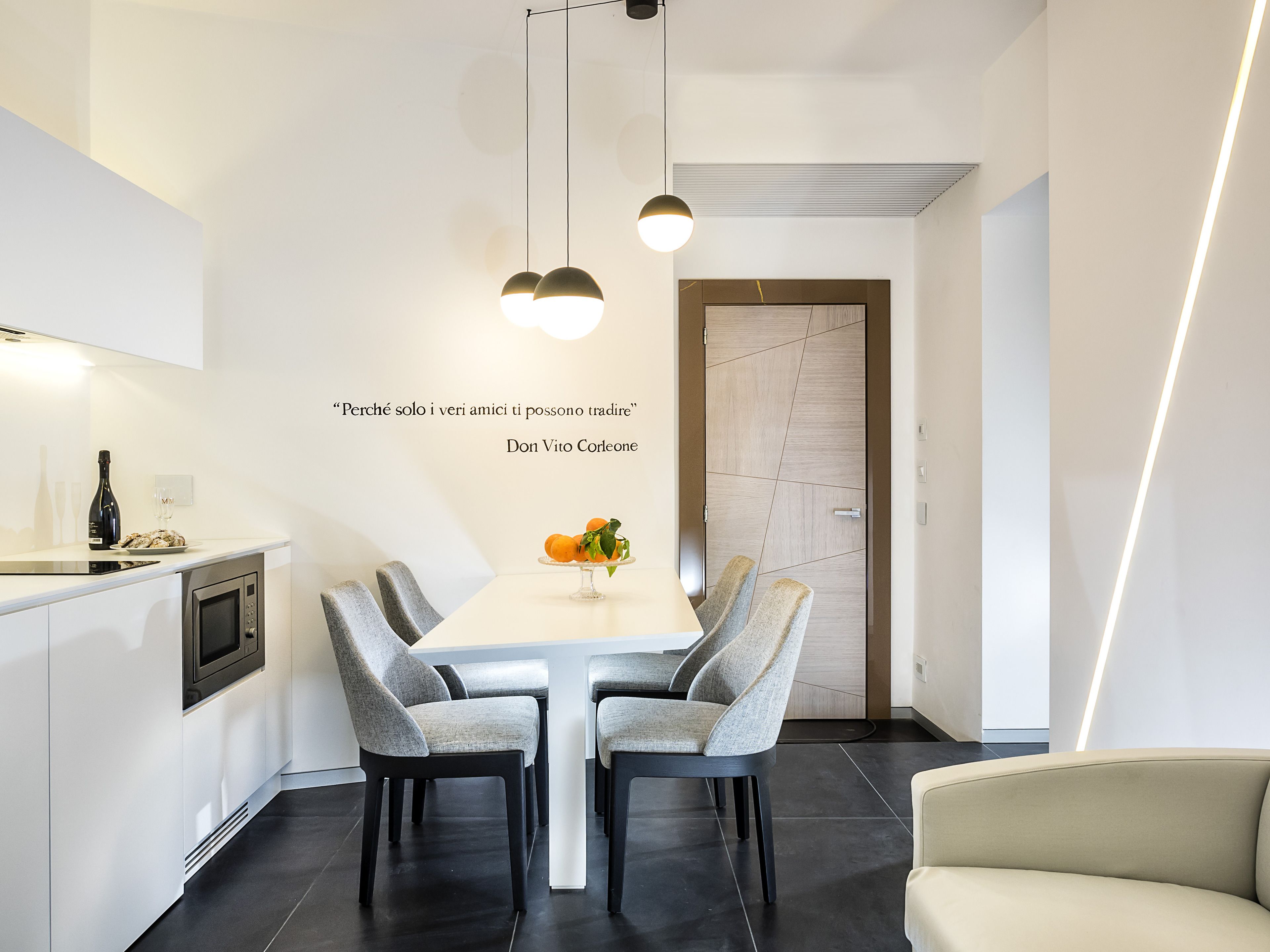 A modern kitchen with a dining table, chairs, and a built-in oven.
