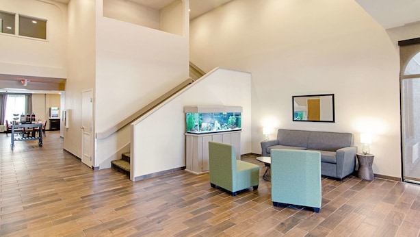A spacious lobby with a staircase, a large aquarium, and seating areas. - Quality Inn & Suites Near Tanger Outlet Mall (Gonzales)