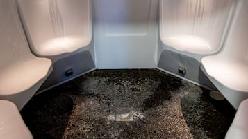 A room with two white tubs and a mosaic floor.