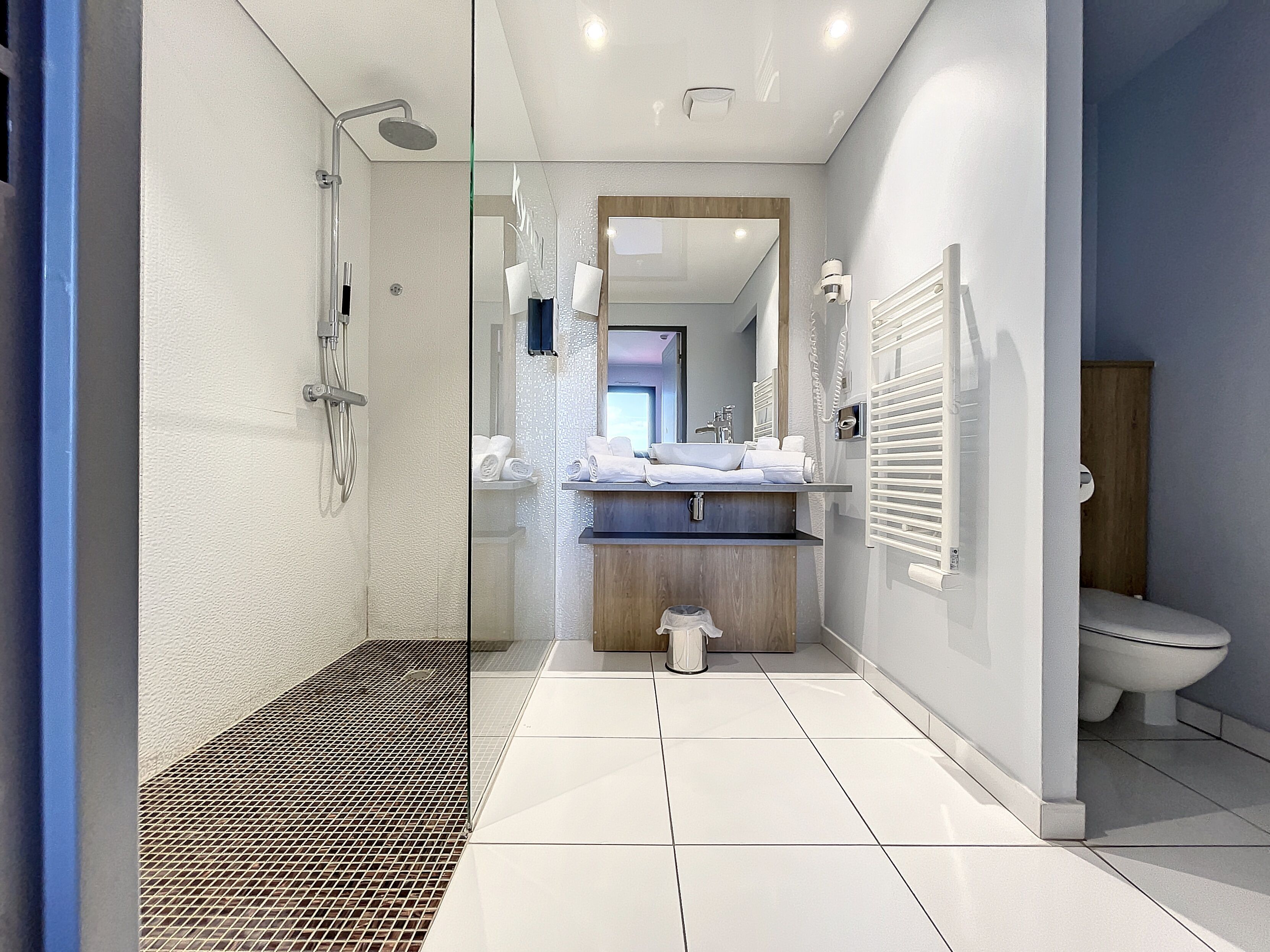 Un baño moderno con ducha, inodoro y lavamanos.