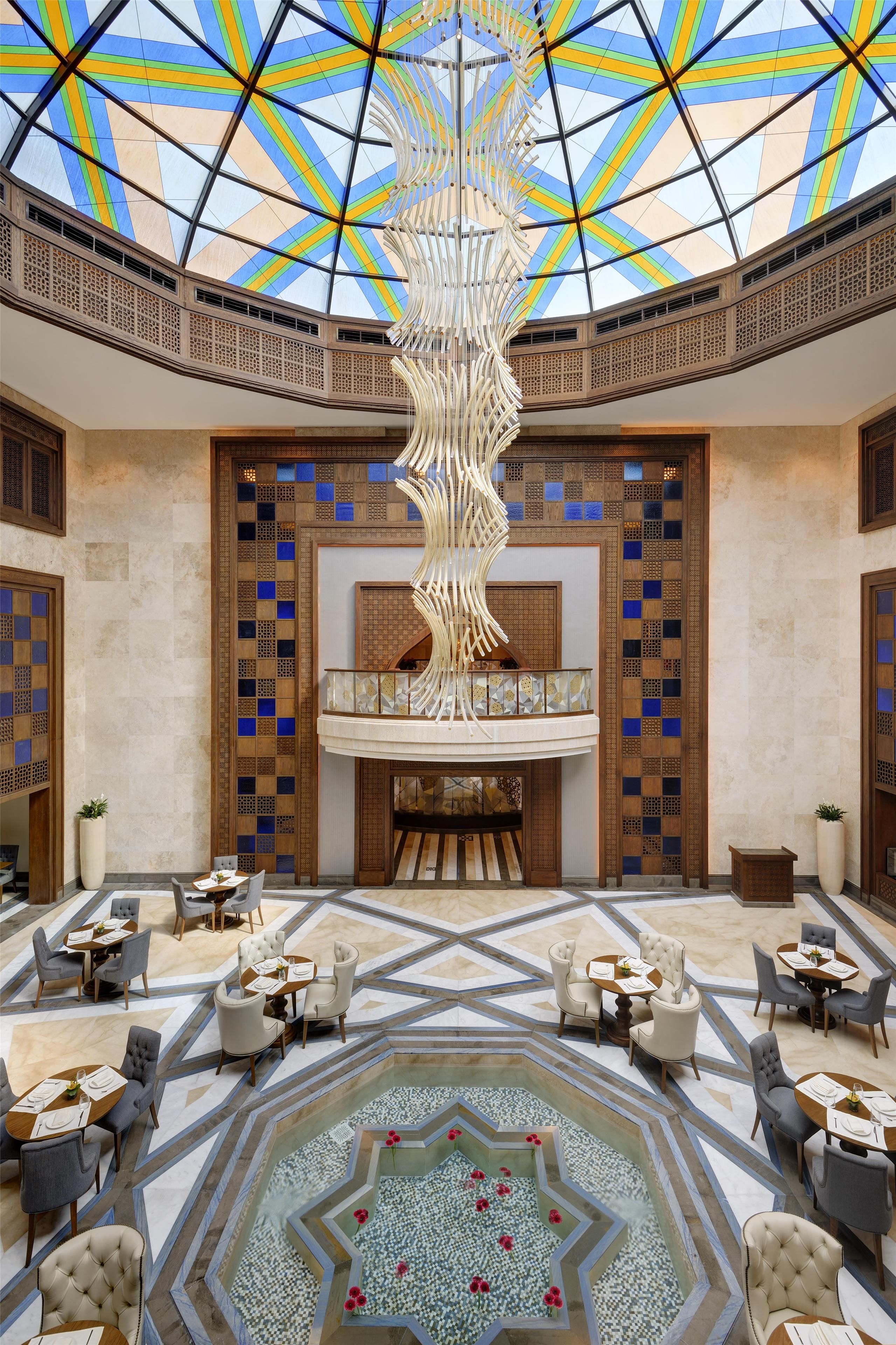 A spacious lobby with a high ceiling, a central decorative column, and a patterned floor.
