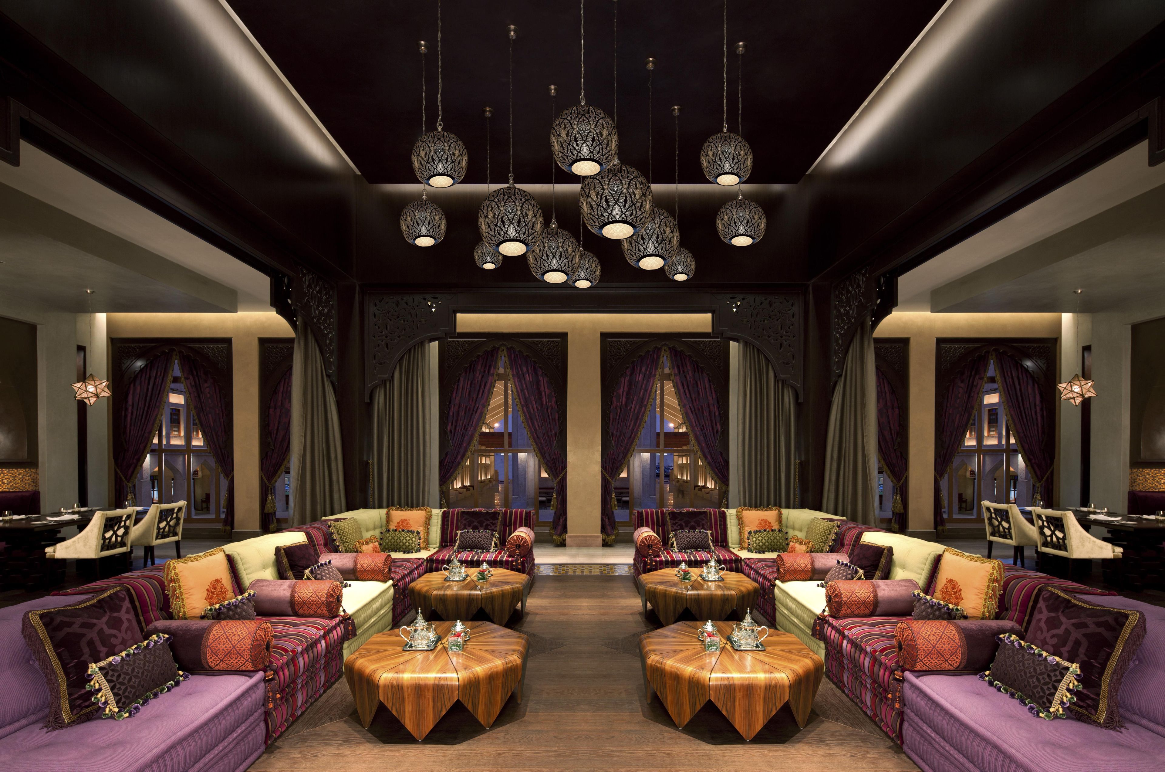 A luxurious interior with ornate chandeliers, plush seating, and a view through large windows.