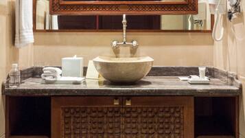 A bathroom with a large mirror, a wooden vanity, a sink, and a hairdryer.