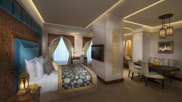 A hotel room with a bed, a desk, a dining area, and a TV.