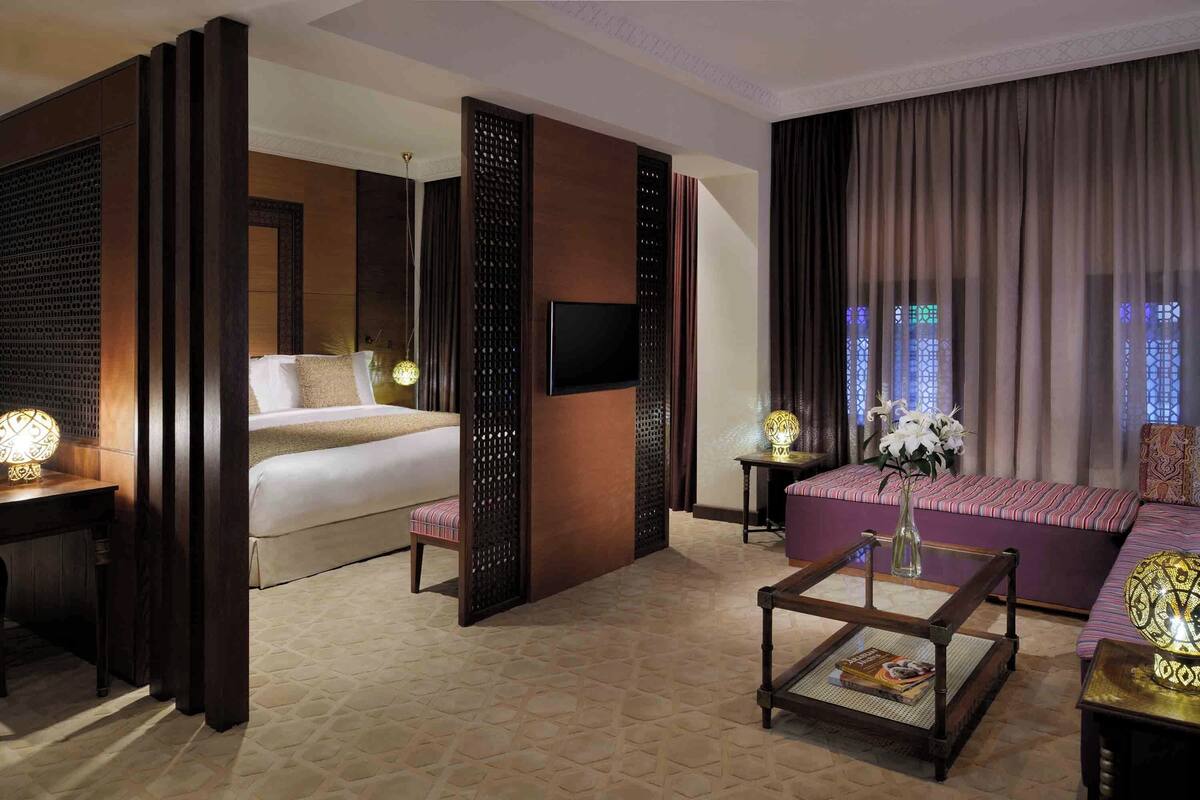 Une chambre d’hôtel avec un lit, un canapé, une table basse et un téléviseur.
