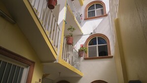 A multi-level building with balconies, potted plants, and arched windows. - Hotel Posada Diamante (Querétaro)