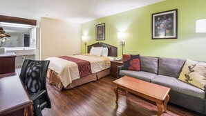 Una habitación de hotel con una cama, un sofá, un escritorio y una silla.