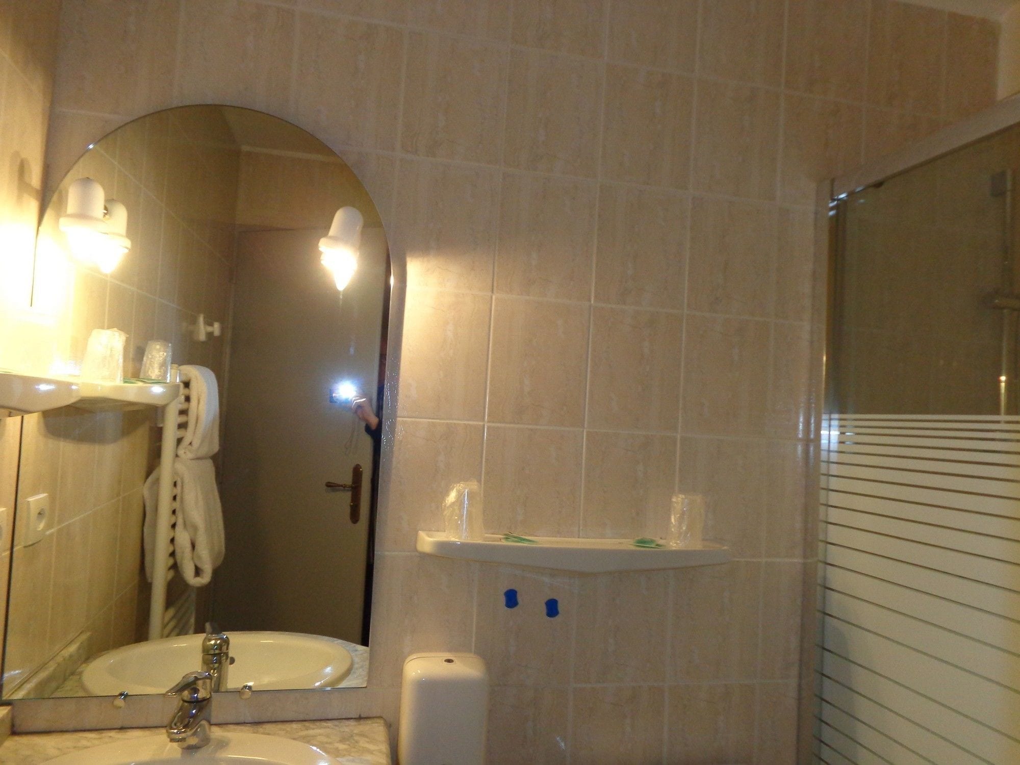 Un baño con lavabo, espejo, toallero y dispensador de jabón.