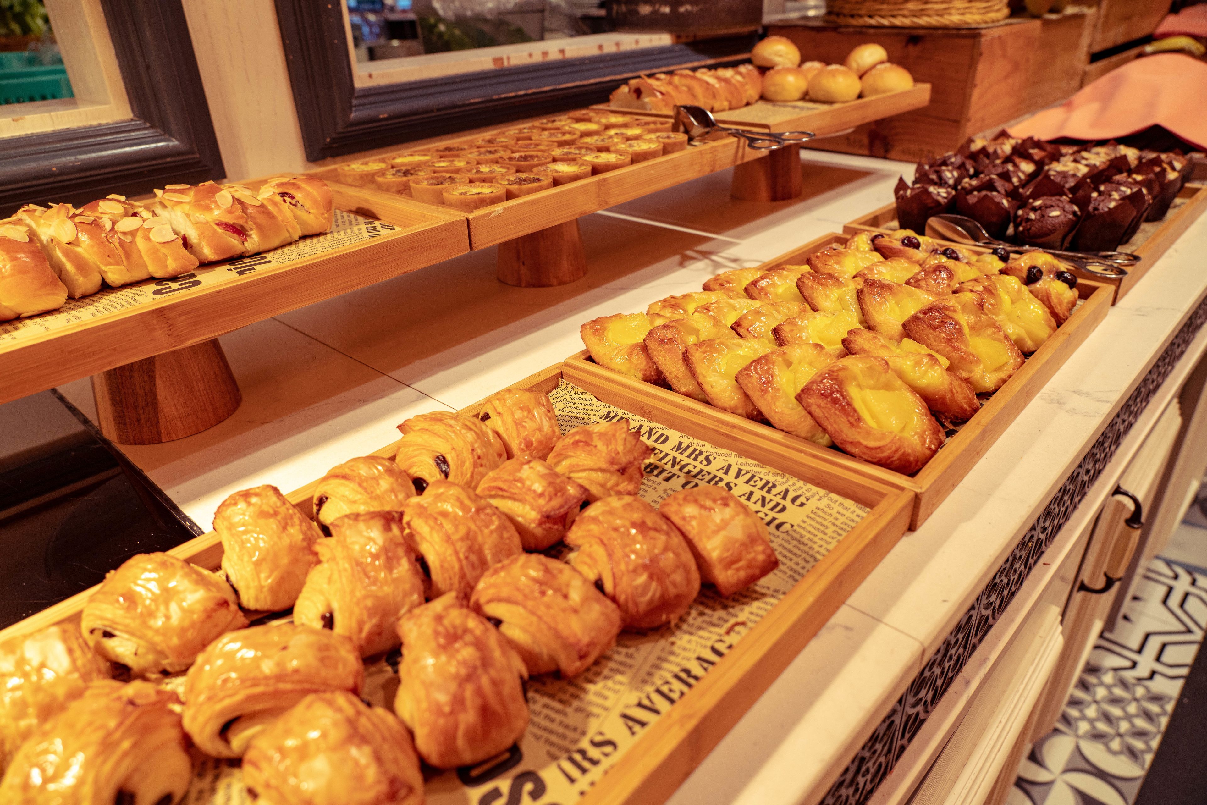 Una vitrina de panadería con diversos tipos de pasteles y pan.