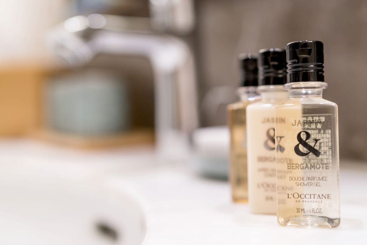 Three bottles of shower gel on a bathroom counter.