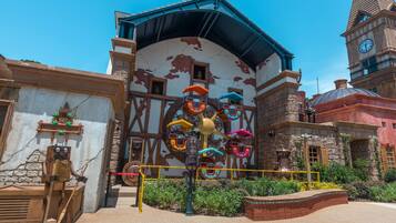 Un bâtiment doté d’une tour horlogée, d’un carrousel et d’une statue de robot en bois.