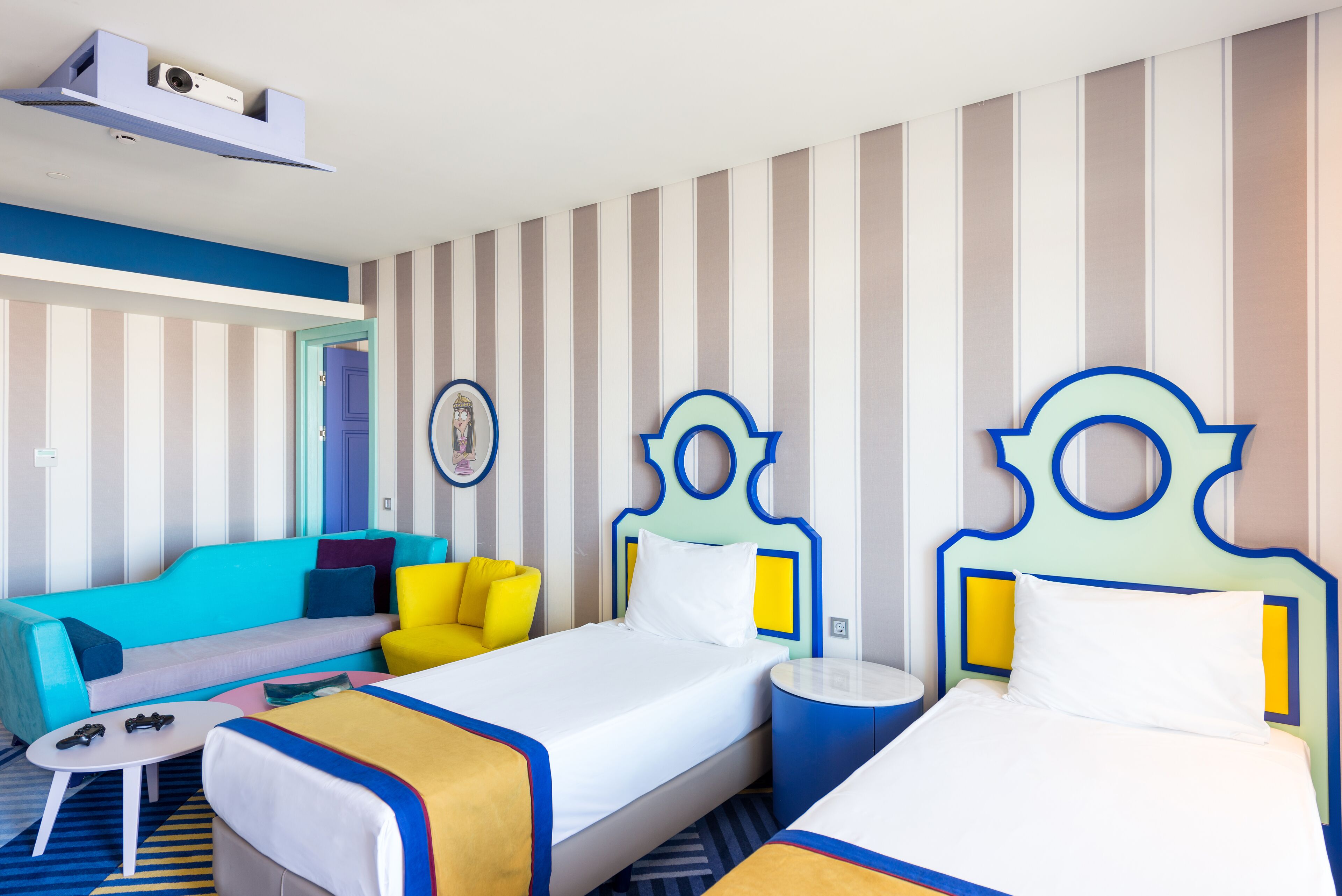 Een hotelkamer met twee bedden, een bank, een klein tafeltje en een aan de muur bevestigde televisie.