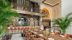A spacious dining area with a long wooden table set for a meal, surrounded by numerous chairs. - The Land Of Legends Kingdom Hotel (Serik)