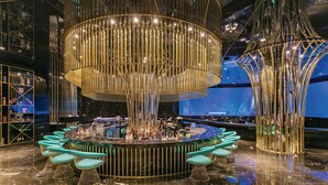 A bar area with a circular bar, multiple seating options, and a large, illuminated chandelier. - The Land Of Legends Kingdom Hotel (Serik)