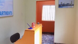 A reception area with a desk, a chair, and a sign that reads "POSH APARTMENTS". - Posh Apartments Self Catering (Lagos)