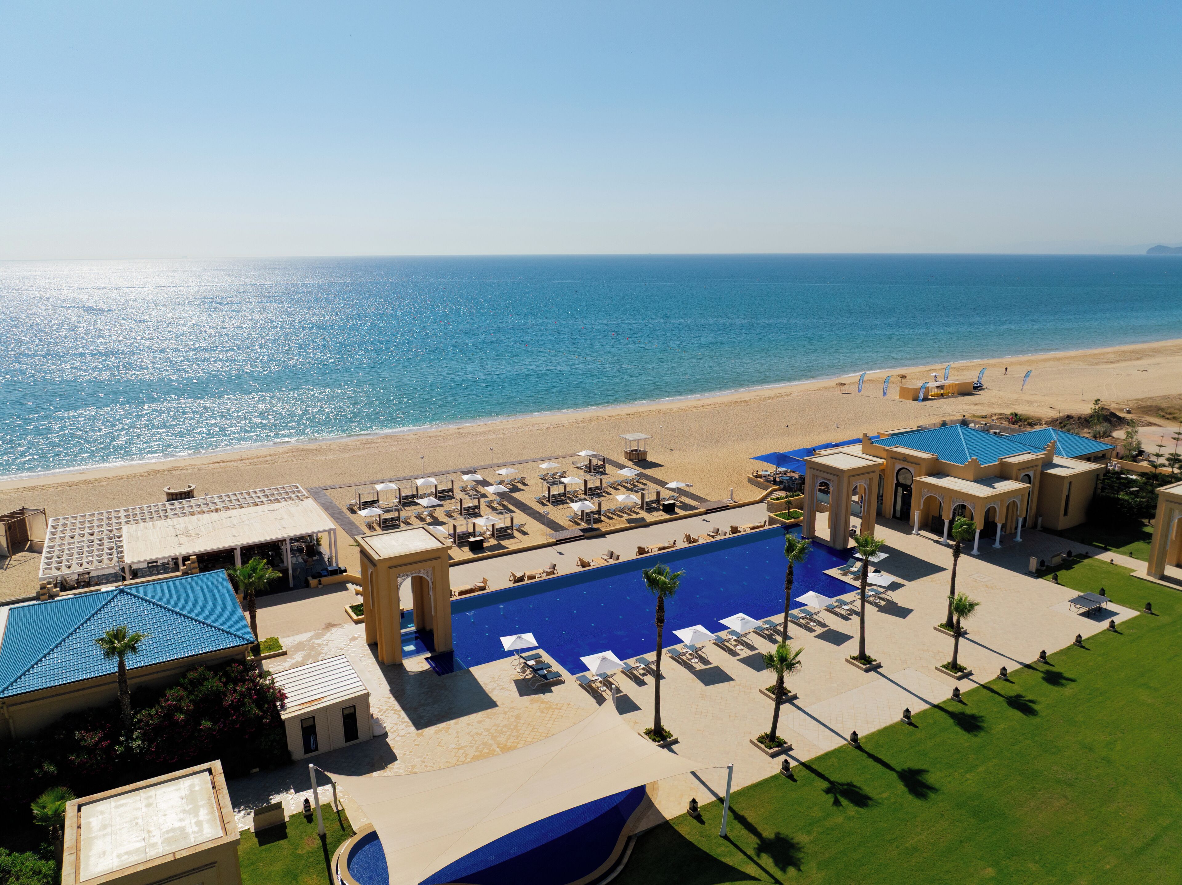 En la playa, sillas reclinables de playa, sombrillas, toallas de playa