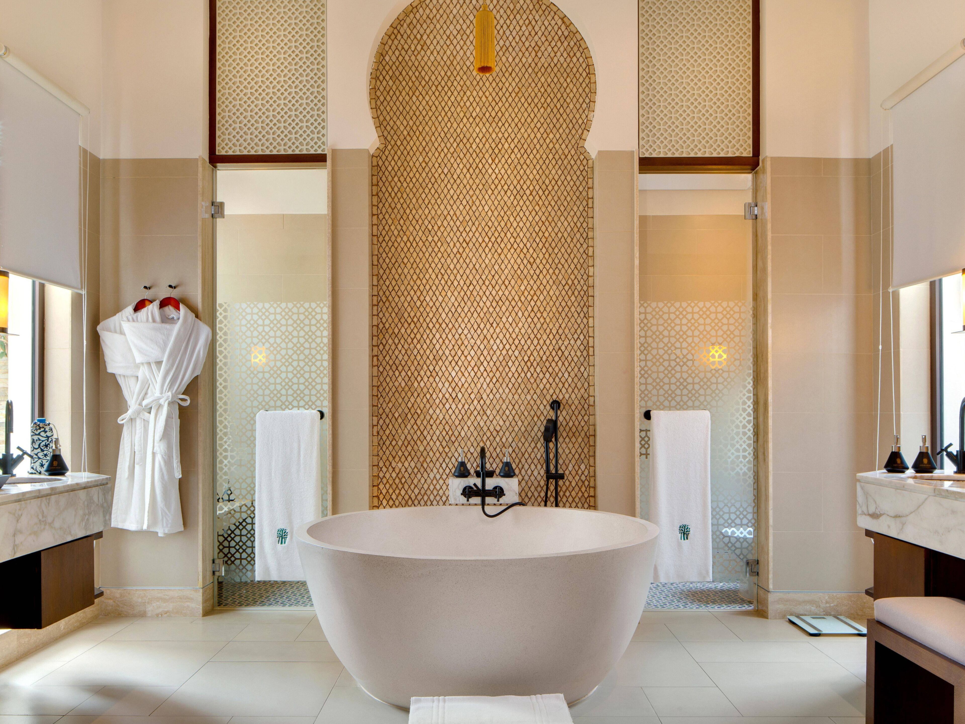A spacious bathroom with a large freestanding bathtub, a glass shower enclosure, and a marble vanity.