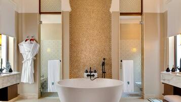 A spacious bathroom with a large freestanding bathtub, a glass shower enclosure, and a marble vanity.